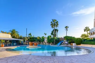 a swimming pool in a resort with palm trees at Appartement Bord de Mer 4 pers / 2 Piscines in Cannes
