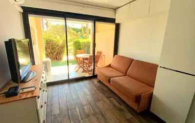 a living room with a couch and a table at Appartement Bord de Mer 4 pers / 2 Piscines in Cannes