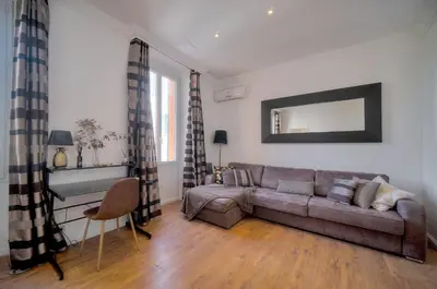 a living room with a couch and a mirror at Le Cal-3 Pièces-2 min Plage-VCA in Cannes