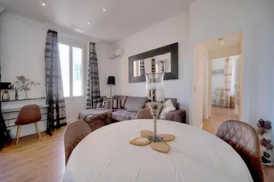 a living room with a table and a couch at Le Cal-3 Pièces-2 min Plage-VCA in Cannes