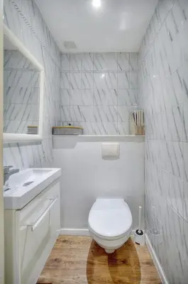 a white bathroom with a toilet and a sink at Le Cal-3 Pièces-2 min Plage-VCA in Cannes