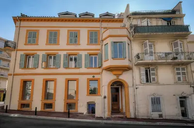 a large orange building on the side of a street at Le Cal-3 Pièces-2 min Plage-VCA in Cannes