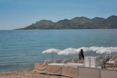 a group of chairs and umbrellas on a beach at Le Cal-3 Pièces-2 min Plage-VCA in Cannes