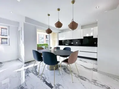 a dining room with a black table and blue chairs at Modern 3 bedroom flat with balcony in Cannes