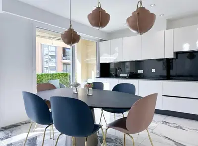 a kitchen with a dining room table and chairs at Modern 3 bedroom flat with balcony in Cannes