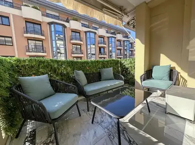 a patio with chairs and a table and a building at Modern 3 bedroom flat with balcony in Cannes