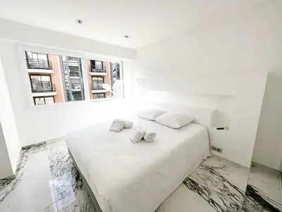 a white bedroom with a large white bed with two pillows at Modern 3 bedroom flat with balcony in Cannes