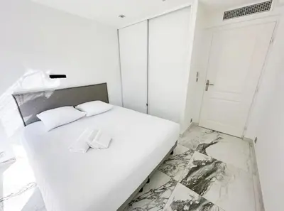 a white bed with two white pillows on it at Modern 3 bedroom flat with balcony in Cannes