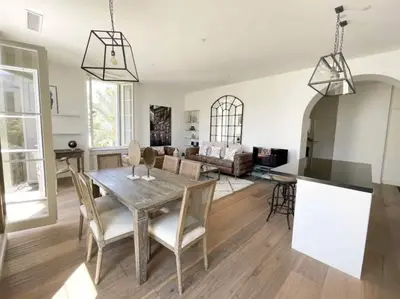 a kitchen and living room with a wooden table and chairs at Beautifully renovated 3 bedroom apartment in the heart of Cannes in Cannes