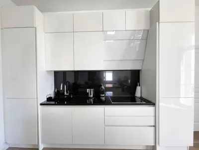 a kitchen with white cabinets and a black sink at Beautifully renovated 3 bedroom apartment in the heart of Cannes in Cannes