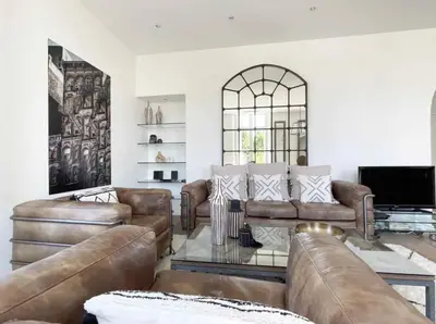 a living room with leather furniture and a flat screen tv at Beautifully renovated 3 bedroom apartment in the heart of Cannes in Cannes