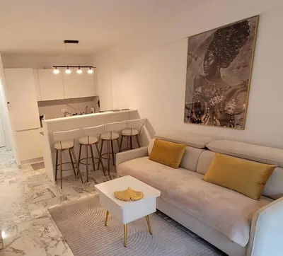a living room with a couch and a kitchen at Bell Appartement Cannes in Cannes