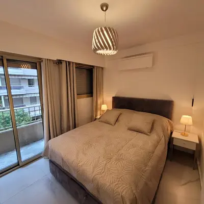 a bedroom with a bed and a large window at Bell Appartement Cannes in Cannes