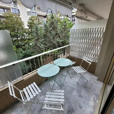 a balcony with two tables and chairs and trees at Bell Appartement Cannes in Cannes