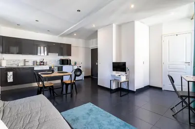 a living room with a table and a kitchen at Les Suisses Apartment Zentral in der schönen Altstadt von Le Suquet 5 min zum Strand WLAN in Cannes
