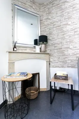 a room with a fireplace with a mirror and two tables at Les Suisses Apartment Zentral in der schönen Altstadt von Le Suquet 5 min zum Strand WLAN in Cannes