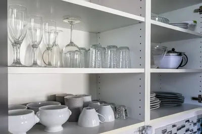 a cupboard filled with glasses and bowls and plates at Les Suisses Apartment Zentral in der schönen Altstadt von Le Suquet 5 min zum Strand WLAN in Cannes