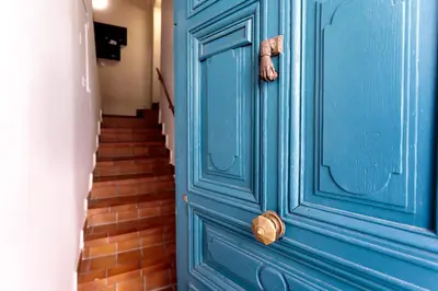a blue door in a hallway with a staircase at Les Suisses Apartment Zentral in der schönen Altstadt von Le Suquet 5 min zum Strand WLAN in Cannes