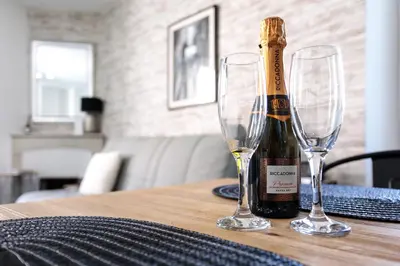 a bottle of champagne and two wine glasses on a table at Les Suisses Apartment Zentral in der schönen Altstadt von Le Suquet 5 min zum Strand WLAN in Cannes