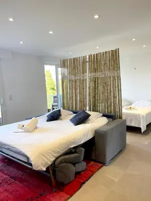 a large bedroom with a large bed and a large window at Le Cèdre Magnifique Appartement à Cannes in Cannes