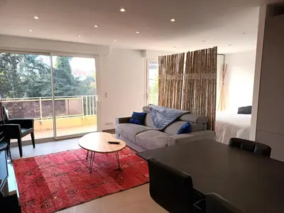 a living room with a couch and a table at Le Cèdre Magnifique Appartement à Cannes in Cannes