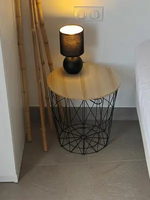 a lamp sitting on a table next to a bed at Le Cèdre Magnifique Appartement à Cannes in Cannes