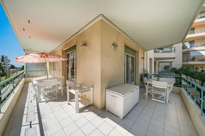 a balcony with tables and chairs and an umbrella at Pleasant 2 bedroom close to the center of Cannes in Cannes