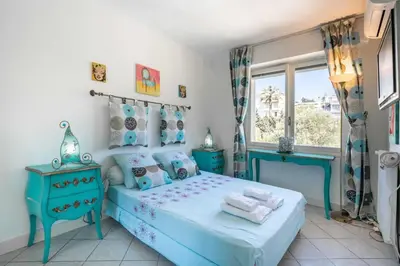 a bedroom with a blue bed and a window at Pleasant 2 bedroom close to the center of Cannes in Cannes
