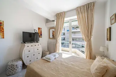 a bedroom with a bed and a tv and a window at Pleasant 2 bedroom close to the center of Cannes in Cannes