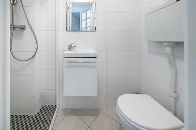 a white bathroom with a toilet and a sink at Pleasant 2 bedroom close to the center of Cannes in Cannes