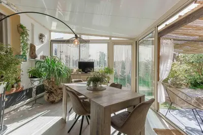 a dining room with a table and some plants at La Maison Fleurie by Halldis in Cannes