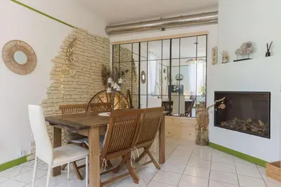 a dining room with a table and chairs and a fireplace at La Maison Fleurie by Halldis in Cannes