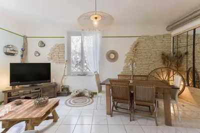 a living room with a table and a television at La Maison Fleurie by Halldis in Cannes