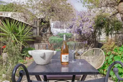 a bottle of wine sitting on a table with two glasses at La Maison Fleurie by Halldis in Cannes