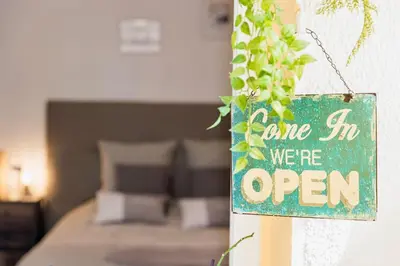 a sign that says come in we are open at La Maison Fleurie by Halldis in Cannes