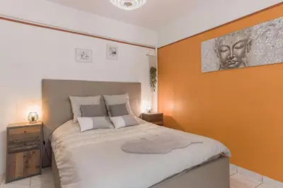 a bedroom with a bed with an orange wall at La Maison Fleurie by Halldis in Cannes