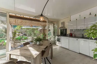 a kitchen with a wooden table and a large window at La Maison Fleurie by Halldis in Cannes