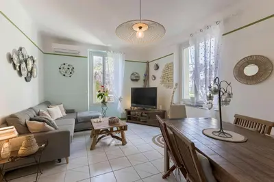 a living room with a couch and a dining room table at La Maison Fleurie by Halldis in Cannes