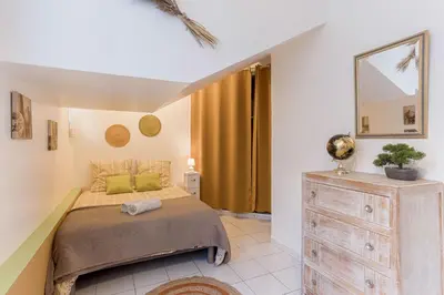 a bedroom with a bed and a dresser and a mirror at La Maison Fleurie by Halldis in Cannes