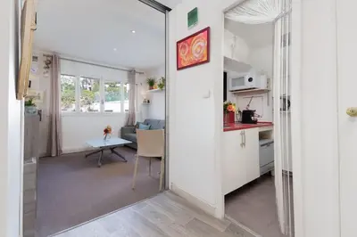 a kitchen and a living room with a table in a room at Le Sorbier By ApiRent #Wifi #Climatisation #Lumineux in Cannes