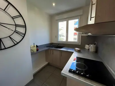 a kitchen with a large clock on the wall at C029-Appartement spacieux a deux pas de la Croisette in Cannes