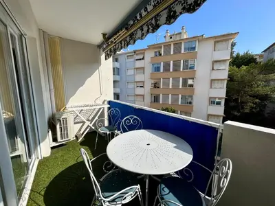 a table and chairs on a balcony with a building at C029-Appartement spacieux a deux pas de la Croisette in Cannes