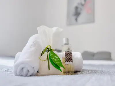a person in a towel with a bottle of soap at Le canopée - Cozy Suquet Cannes Centre in Cannes