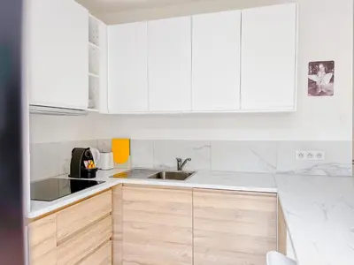 a kitchen with white cabinets and a sink at Le canopée - Cozy Suquet Cannes Centre in Cannes