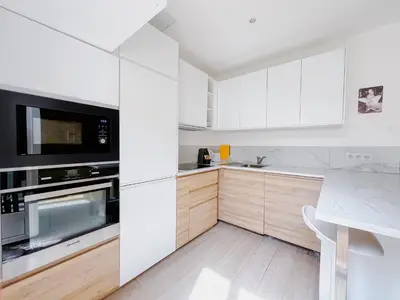 a kitchen with white cabinets and a counter top at Le canopée - Cozy Suquet Cannes Centre in Cannes