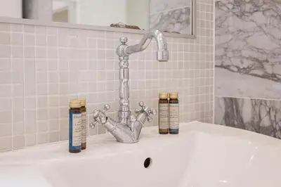 a bath tub with a faucet and three bottles on it at 