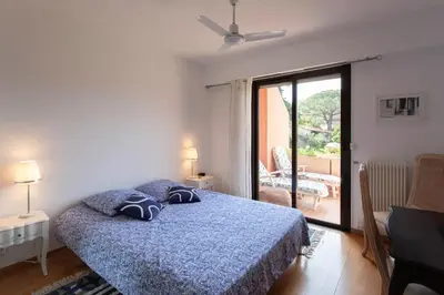 a bedroom with a bed and a sliding glass door at villa dans résidence à Cannes in Cannes