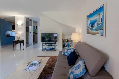 a living room with a couch and a tv at villa dans résidence à Cannes in Cannes