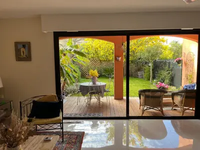 a living room with a sliding glass door with a table at villa dans résidence à Cannes in Cannes