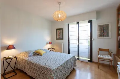 a bedroom with a bed and a chandelier at villa dans résidence à Cannes in Cannes
